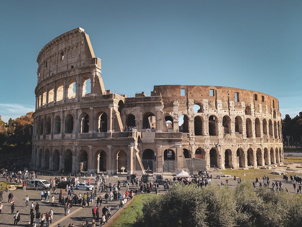Historic Colosseum in Rome with tourists, showcasing ancient Roman architecture.