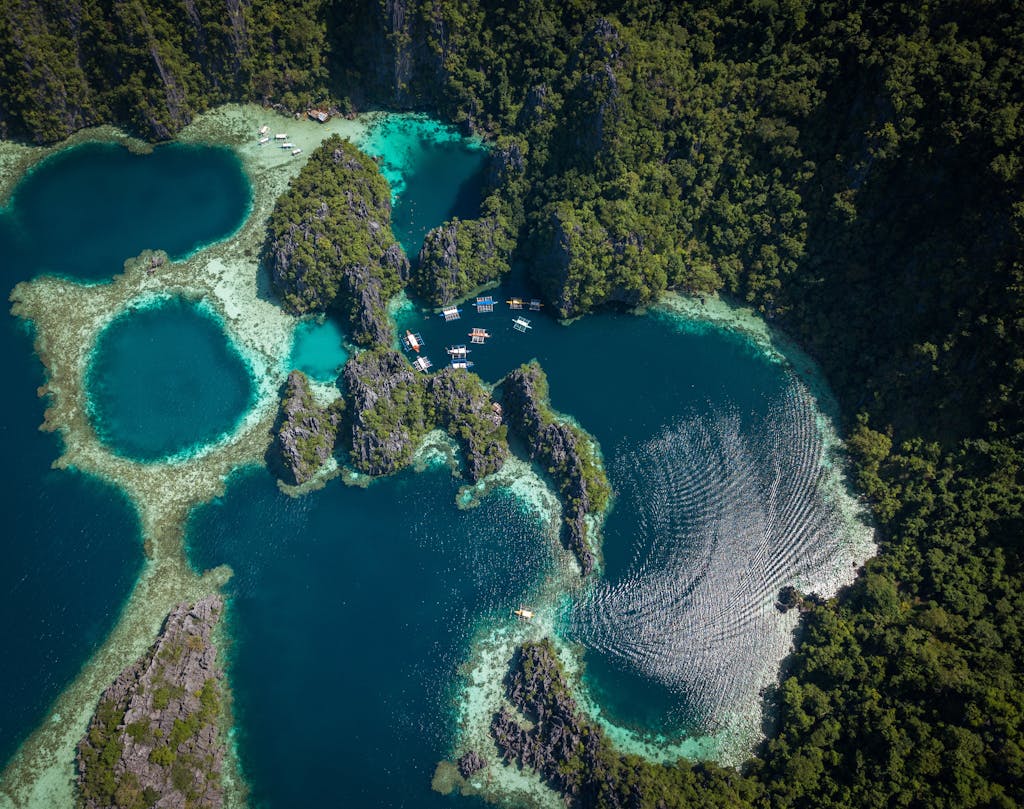 Stunning aerial view of vibrant blue lakes and lush greenery in Coron, Philippines.