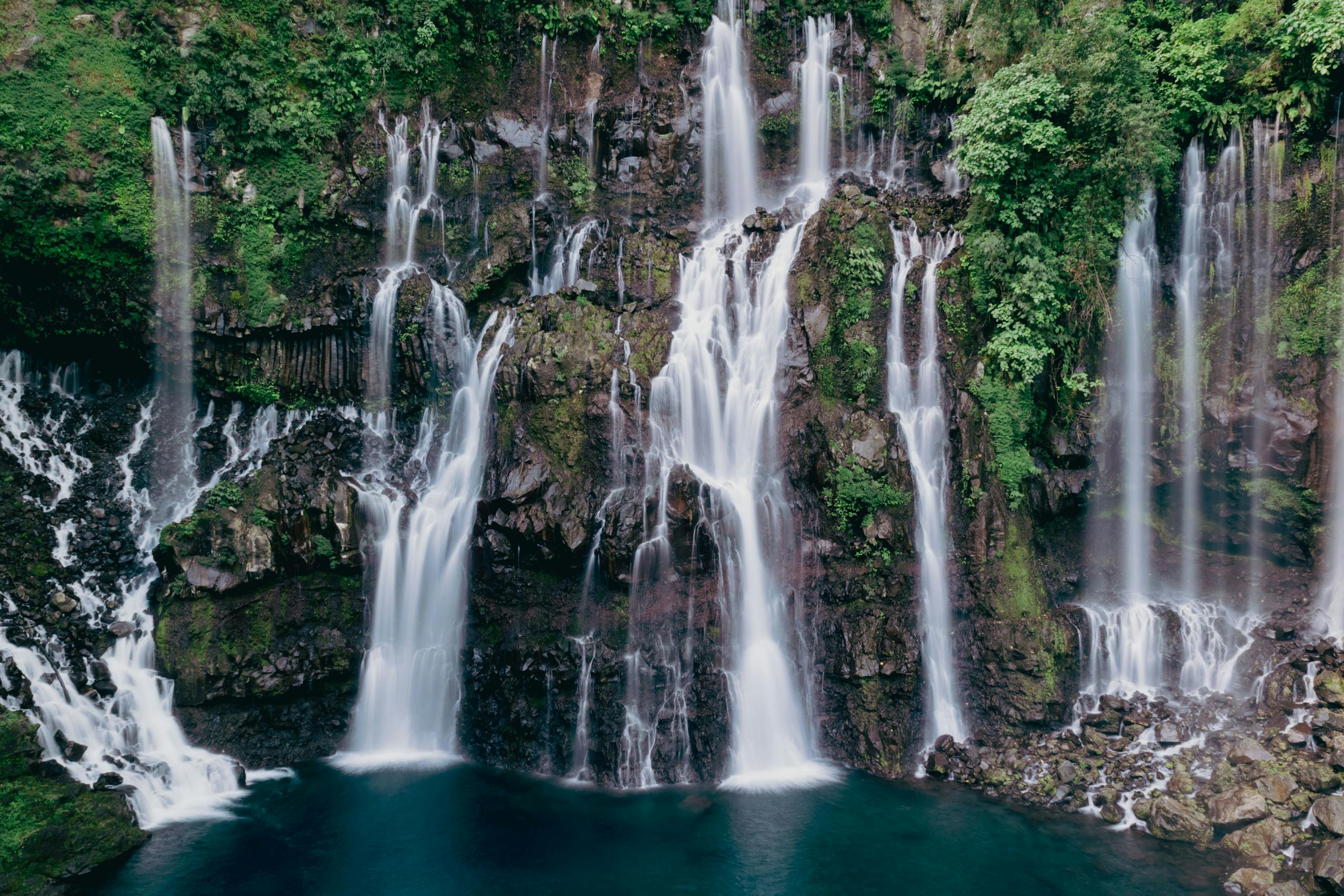 Stunning waterfall in lush greenery at Réunion Island, showcasing pure nature's beauty.