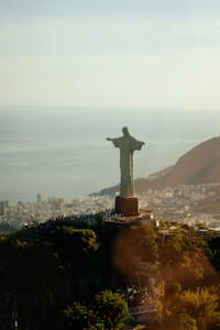Majestic aerial view of Christ the Redeemer statue overlooking Rio de Janeiro at sunset.